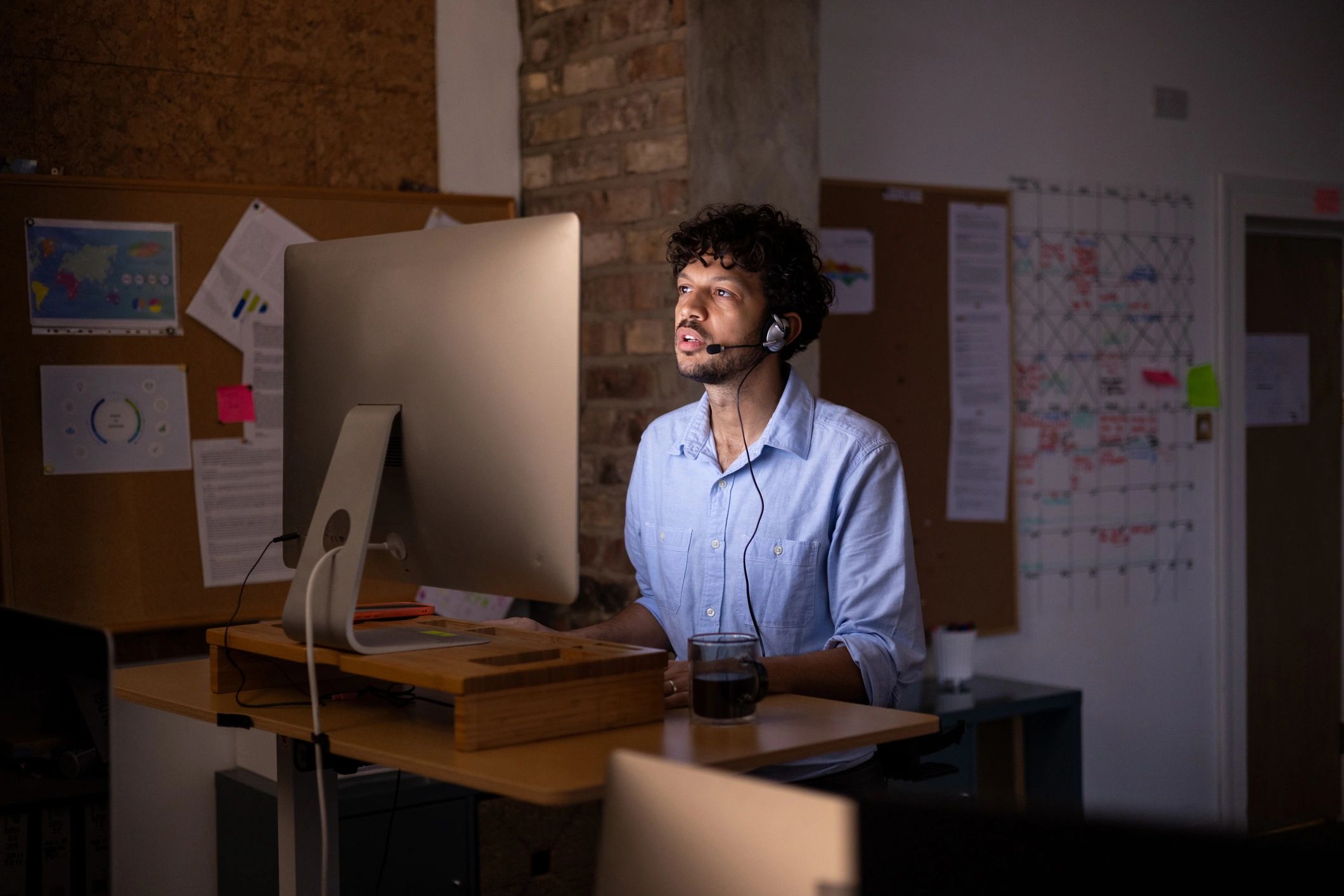 Support specialist working at a standing desk with headset